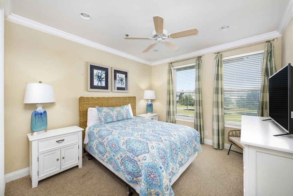 A bedroom with a bed, nightstand, and television.