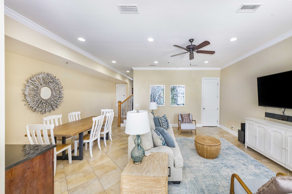 A living room with a wooden table and white chairs.