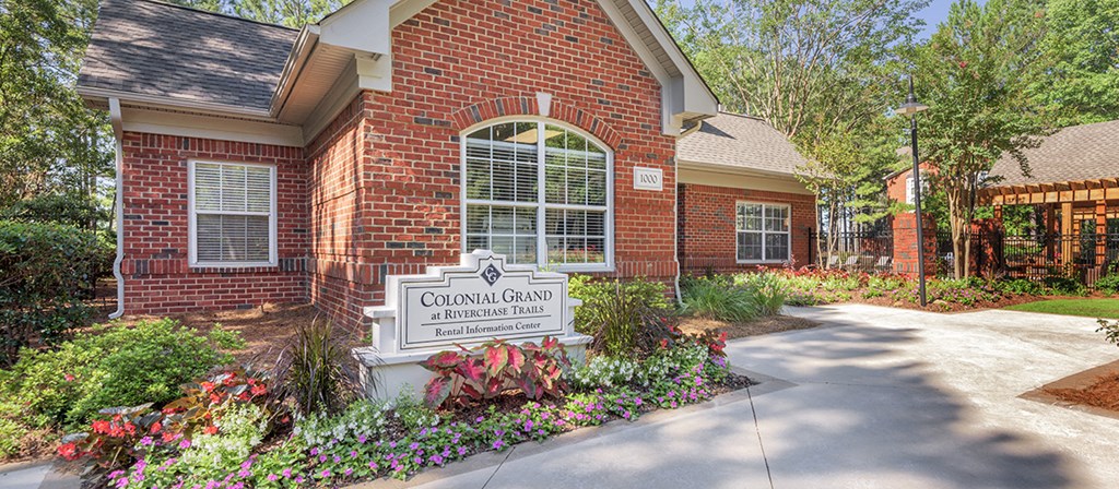 a sidewalk in front of a brick house with a sign for covenant care apartments