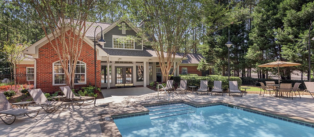 the pool and patio of a house with chairs and a swimming pool