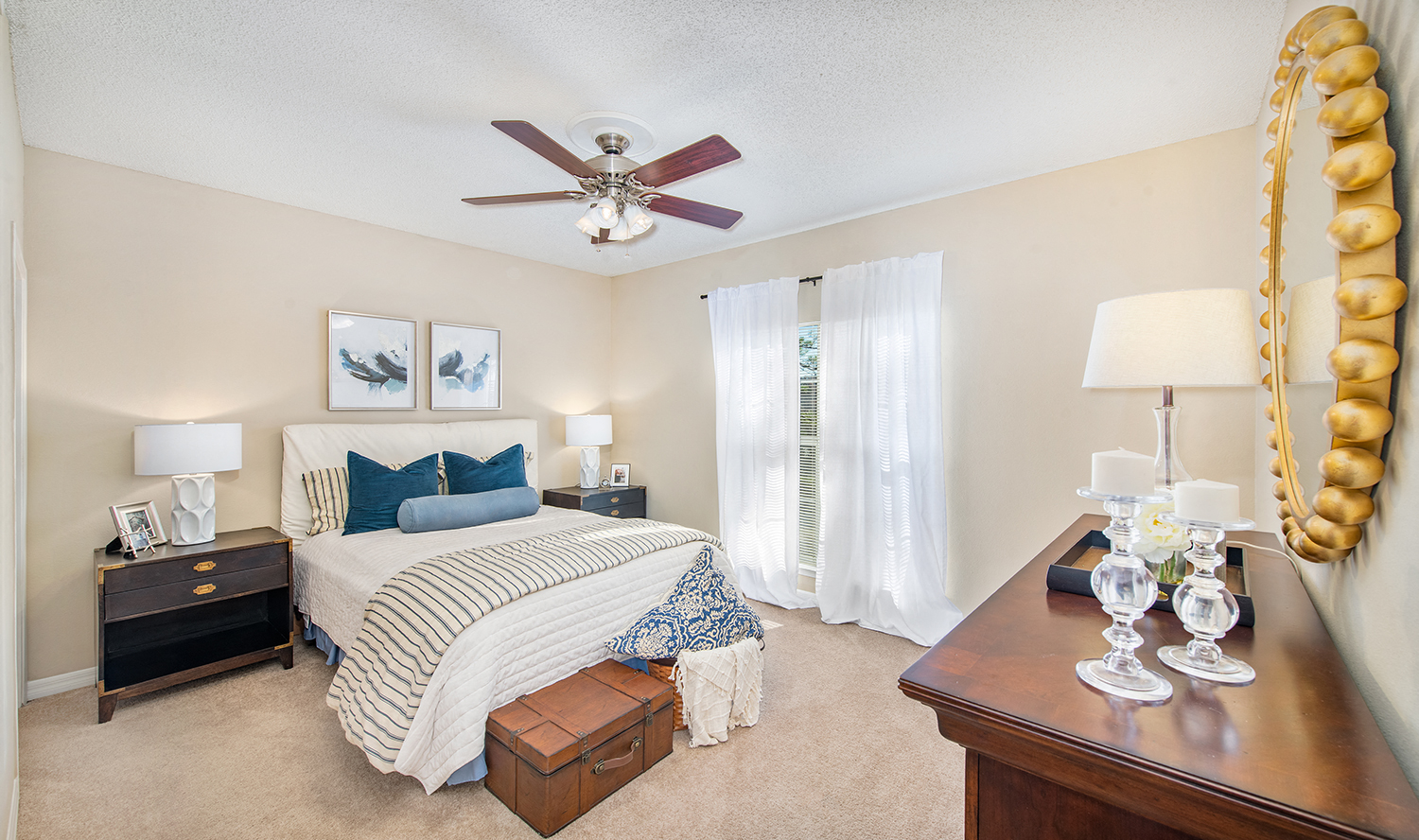 a bedroom with a large bed and a ceiling fan