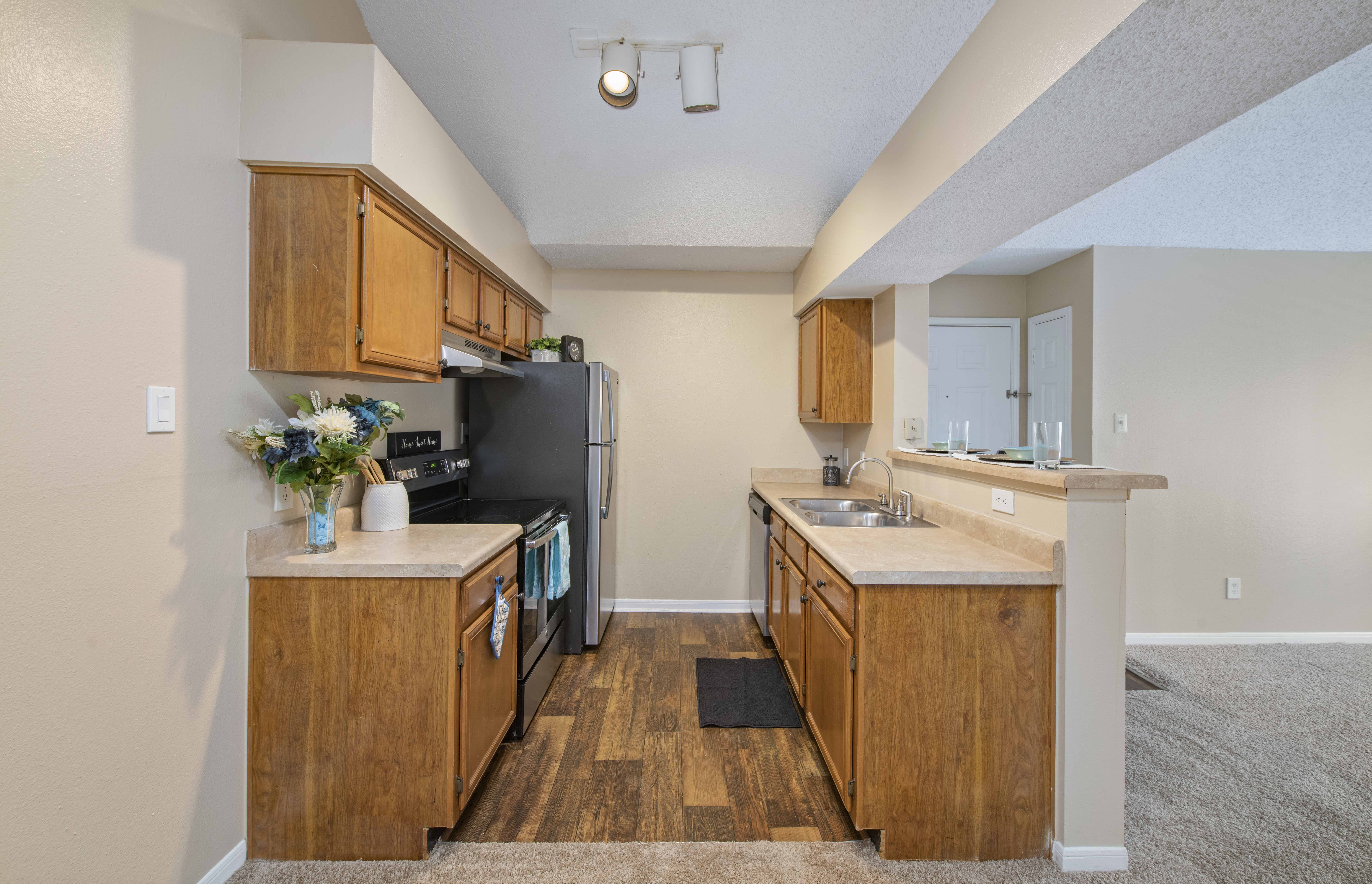 an empty kitchen with wooden cabinets and stainless steel appliances