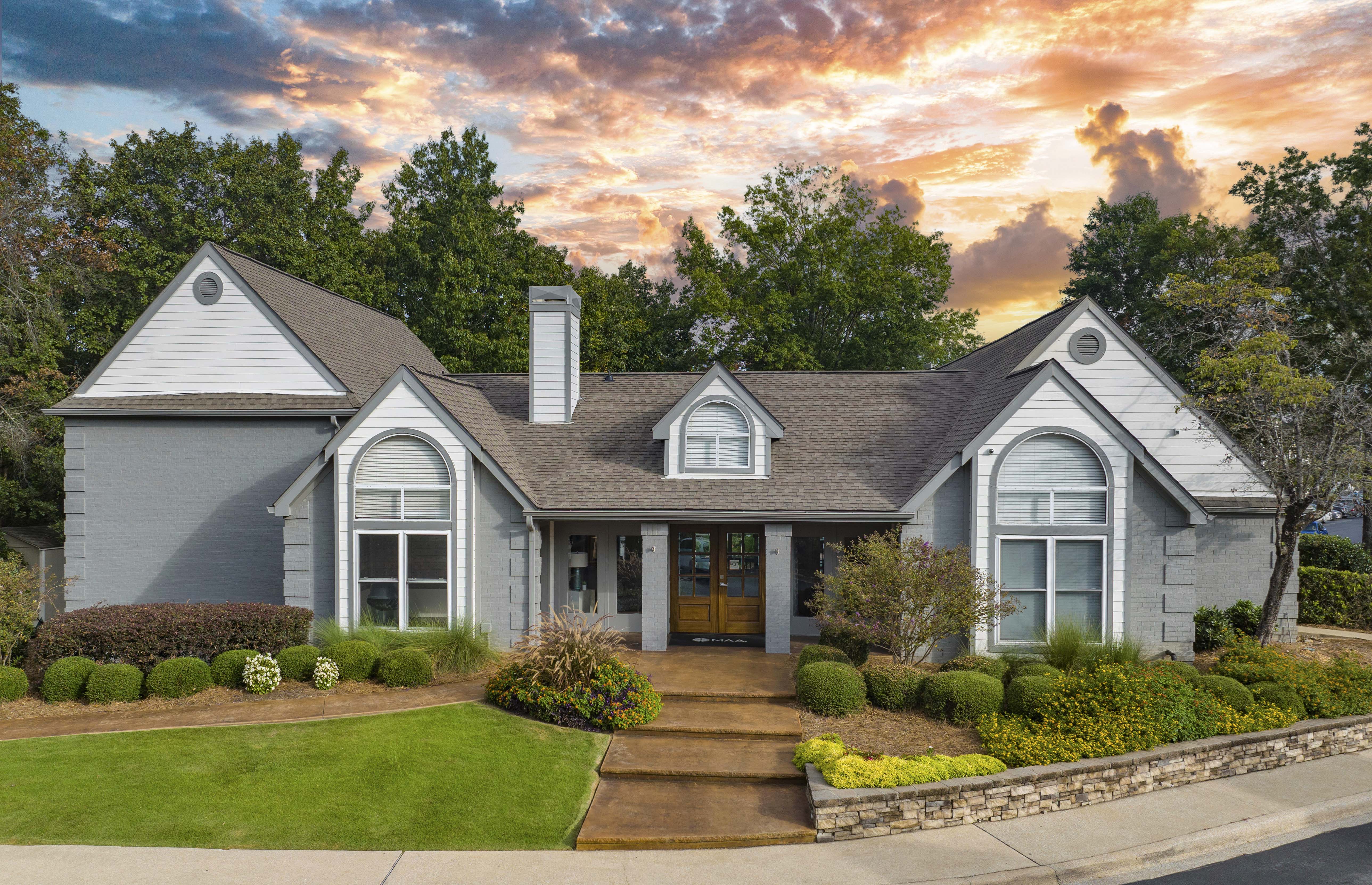 the front of a house with a sunset in the background