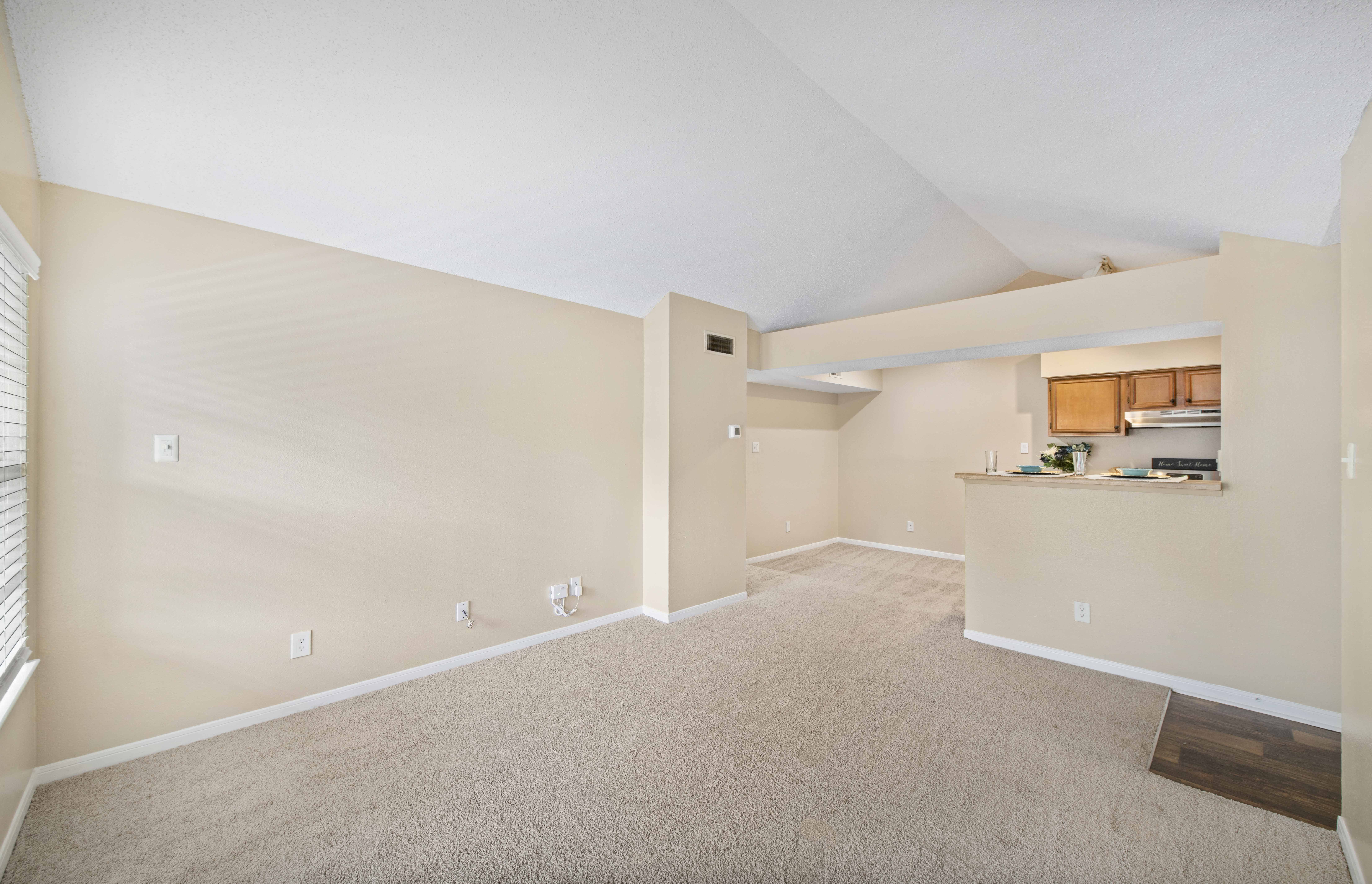 the spacious living room and kitchen in a renovated house