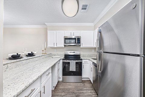A kitchen with a refrigerator on the right side.