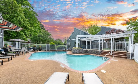 A pool surrounded by a fence with a building in the background.
