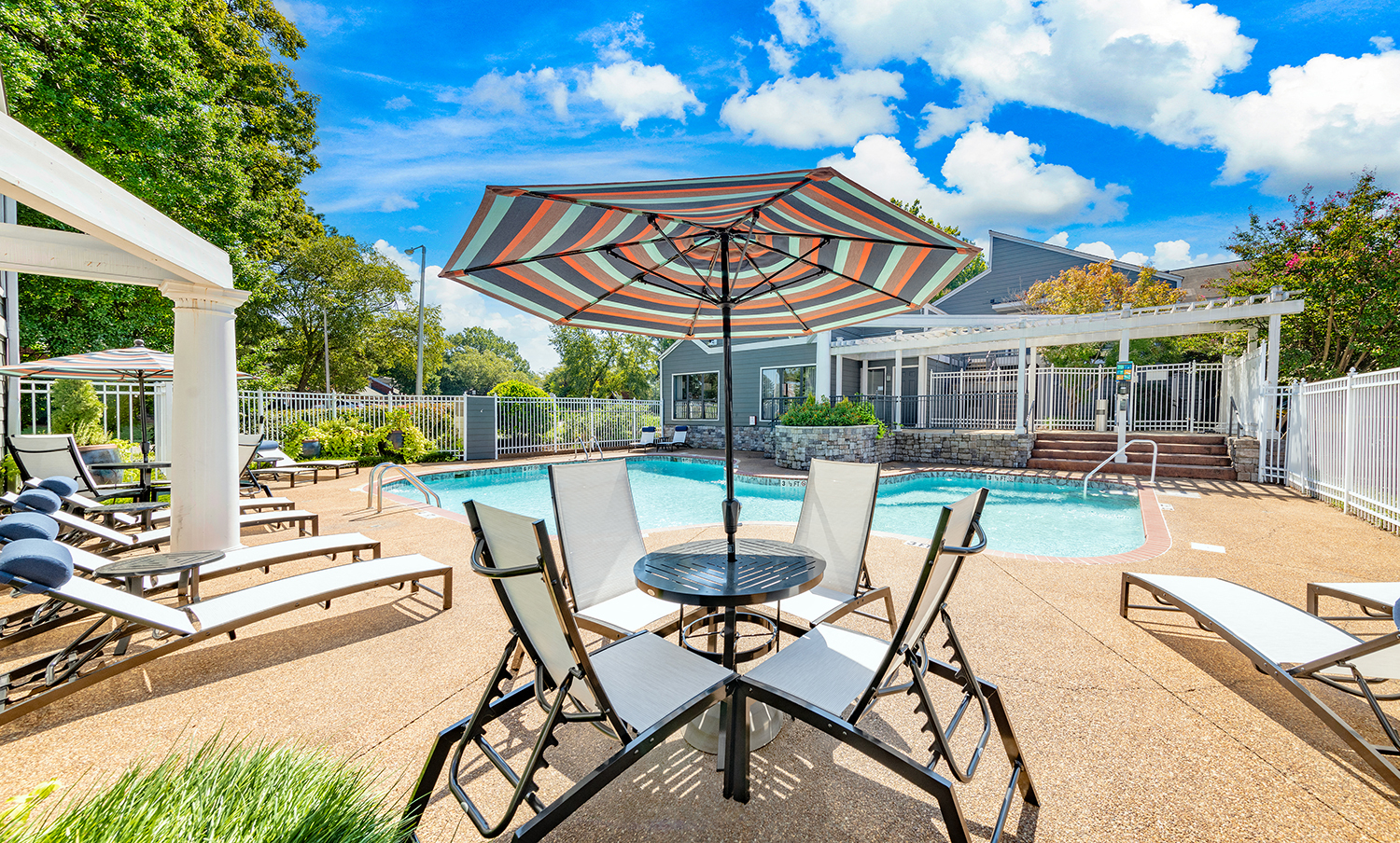our apartments have a pool and patio with chairs and umbrellas