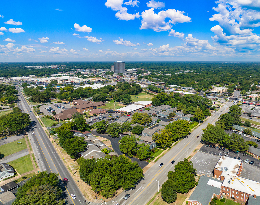 an aerial view of a city with cars driving down a street