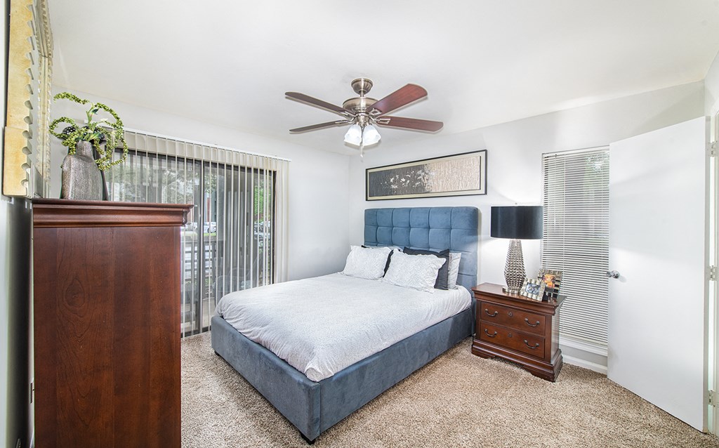 a bedroom with a bed and a ceiling fan