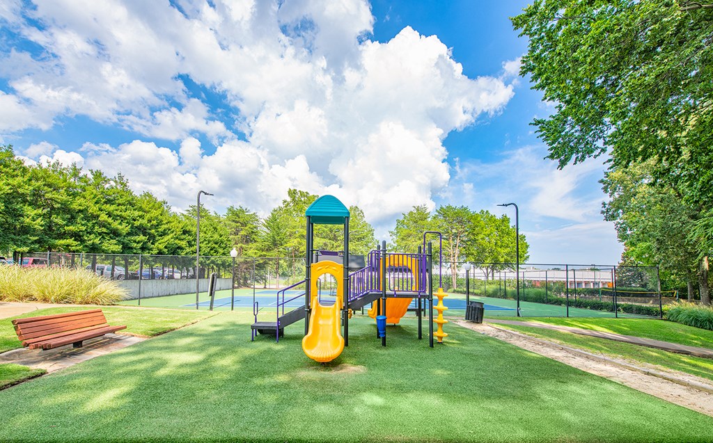 a playground at a park with a yellow swing set