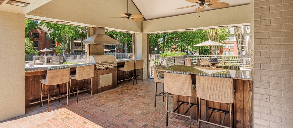 a large outdoor kitchen with a bar and chairs