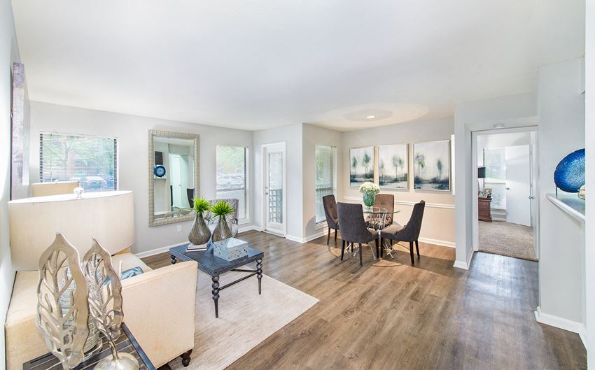 a living room and dining room with a table and chairs
