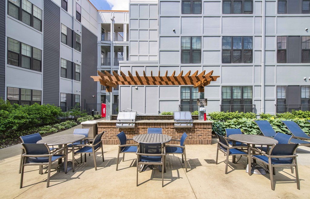an outdoor patio with tables and chairs at an apartment complex