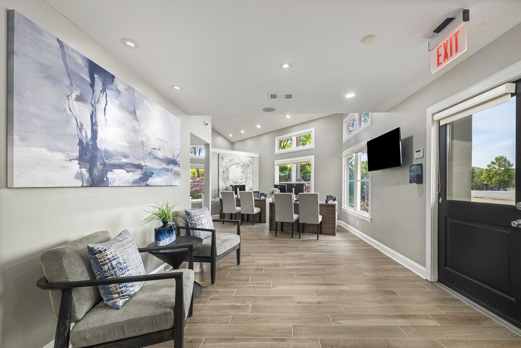 a living room with a table and chairs and a door to a dining room