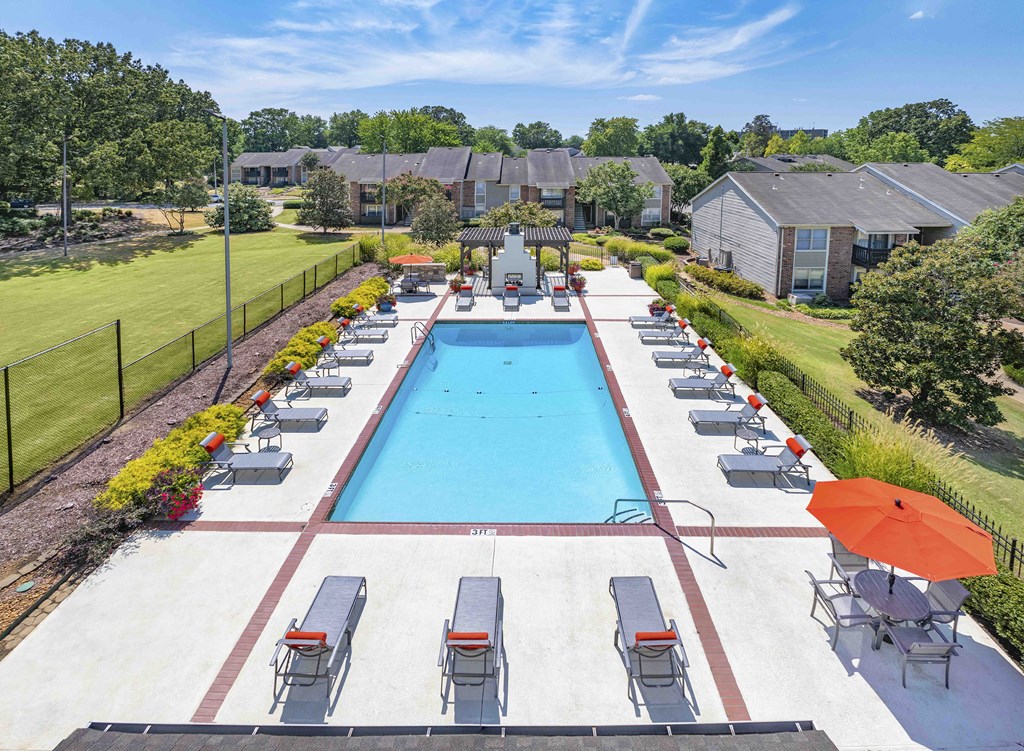an aerial view of a swimming pool with chairs and umbrellas