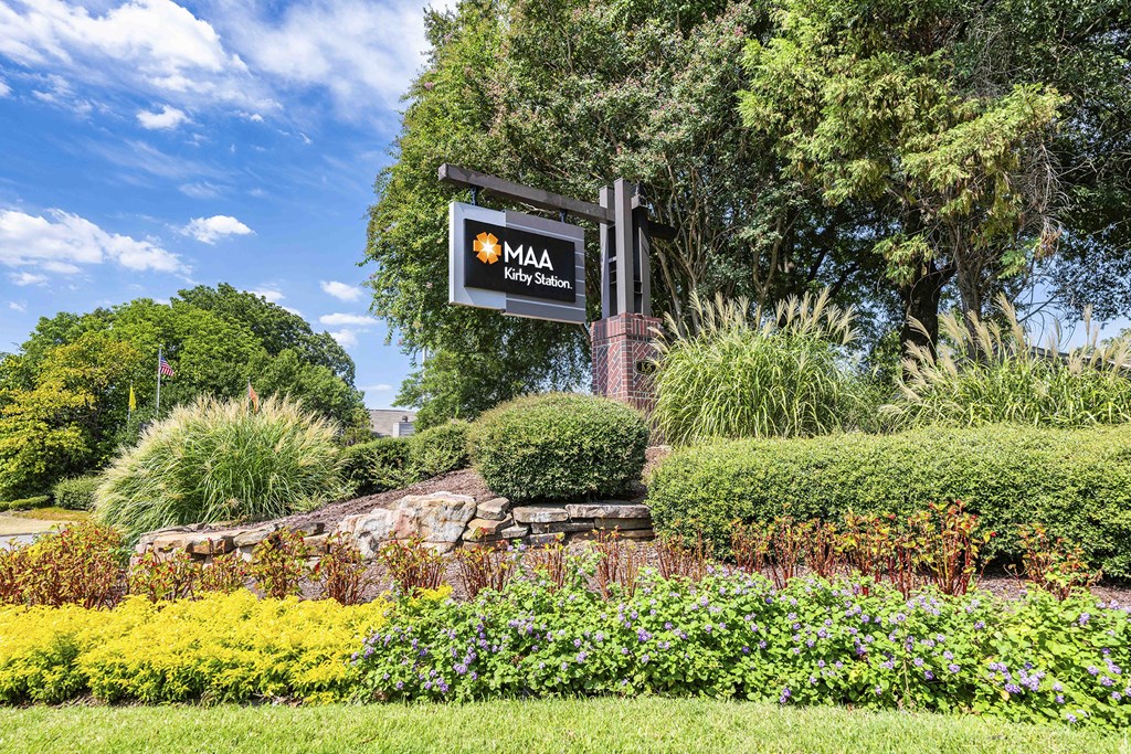 a sign for the mall in front of a garden