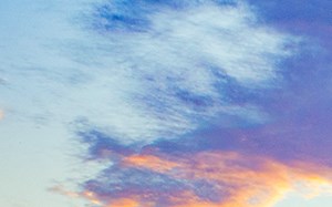 a house with a driveway and a sunset in the sky