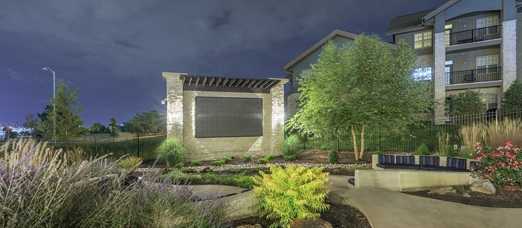 a building with a large window in the middle of a garden