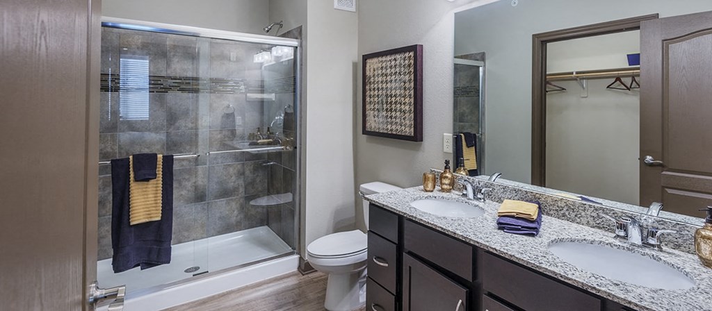 a bathroom with two sinks and a shower and a toilet