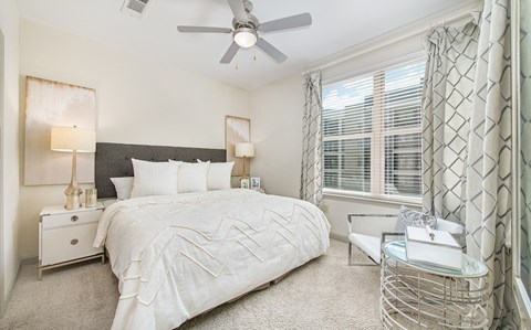 a bedroom with a large bed and a ceiling fan