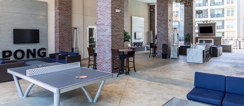 a living room with a ping pong table and a television