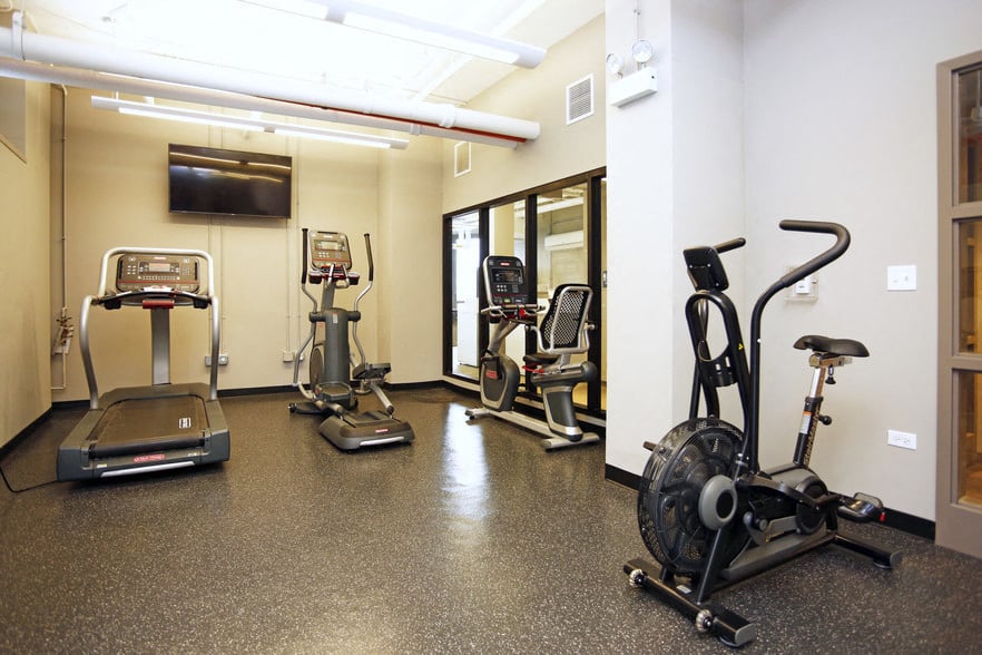 A gym with treadmills, elliptical machines, and stationary bikes.