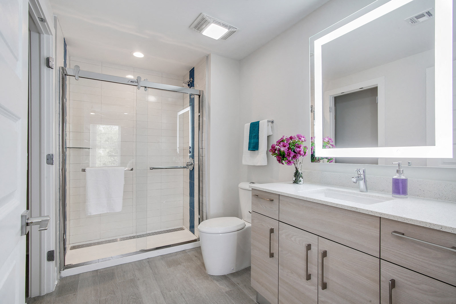 a bathroom with a shower and a sink and a mirror