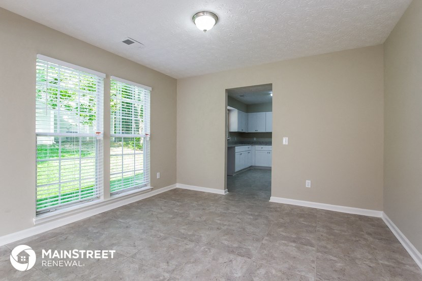 the living room and kitchen of a manufactured home with large windows