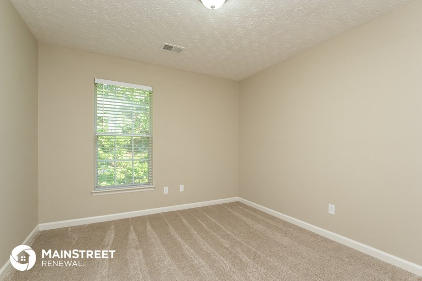 an empty room with carpet and a window