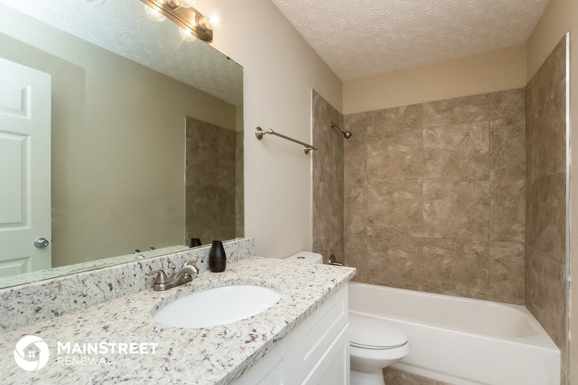 a bathroom with a sink and a tub and a mirror