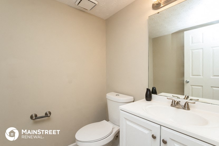 a bathroom with a sink toilet and a mirror