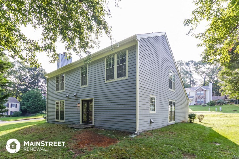 a renovated home with a blue house and a green lawn