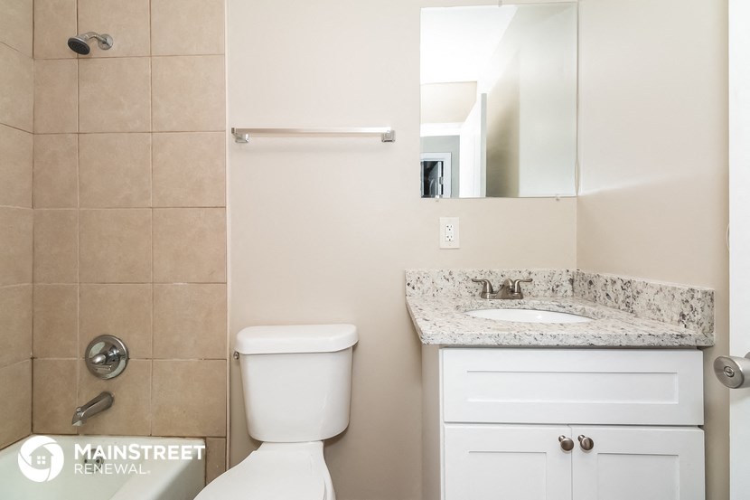 a bathroom with a toilet and a sink and a mirror