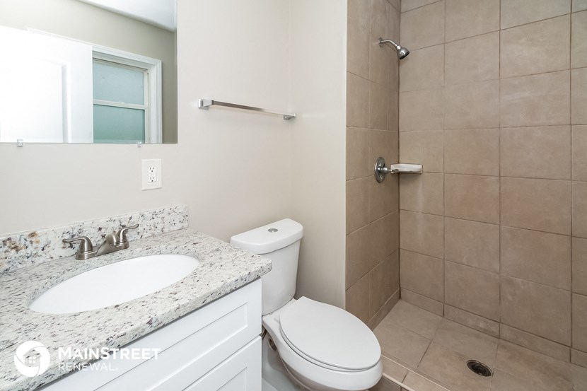 a bathroom with a toilet and a sink and a shower