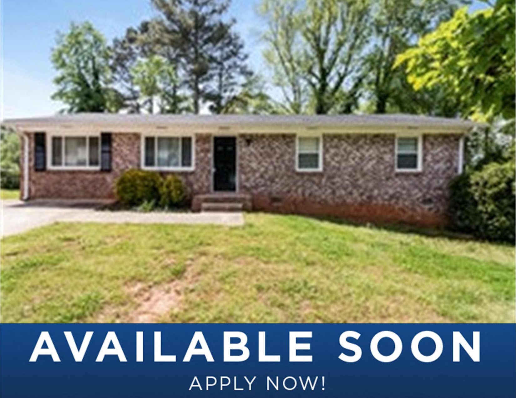 a small brick house with a lawn in front of it