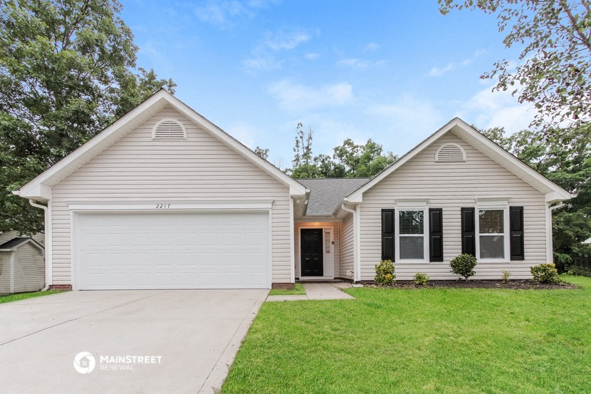 a white house with a lawn and a driveway