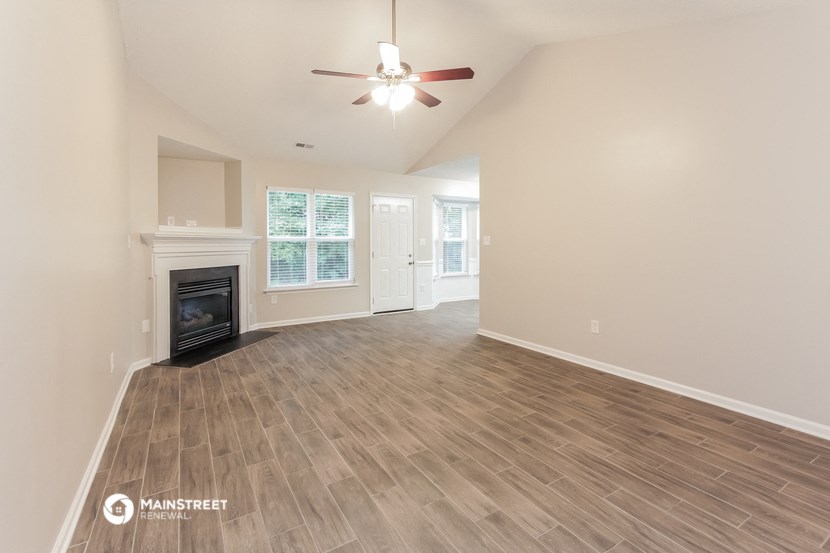 a living room with a fireplace and a ceiling fan