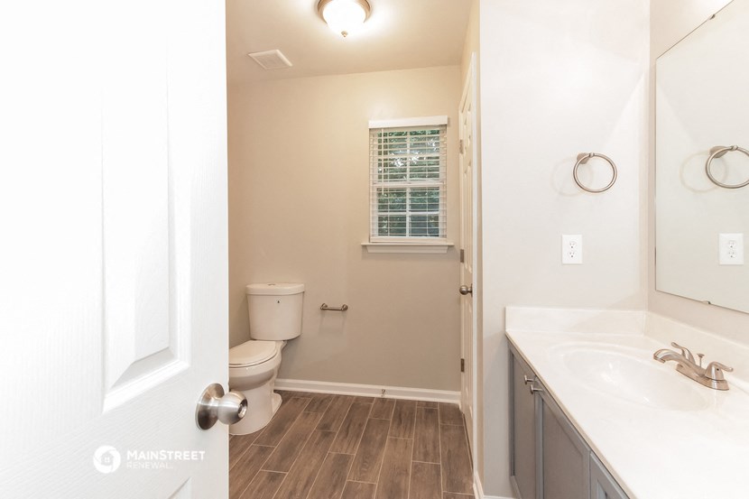 a bathroom with a toilet and a sink and a mirror
