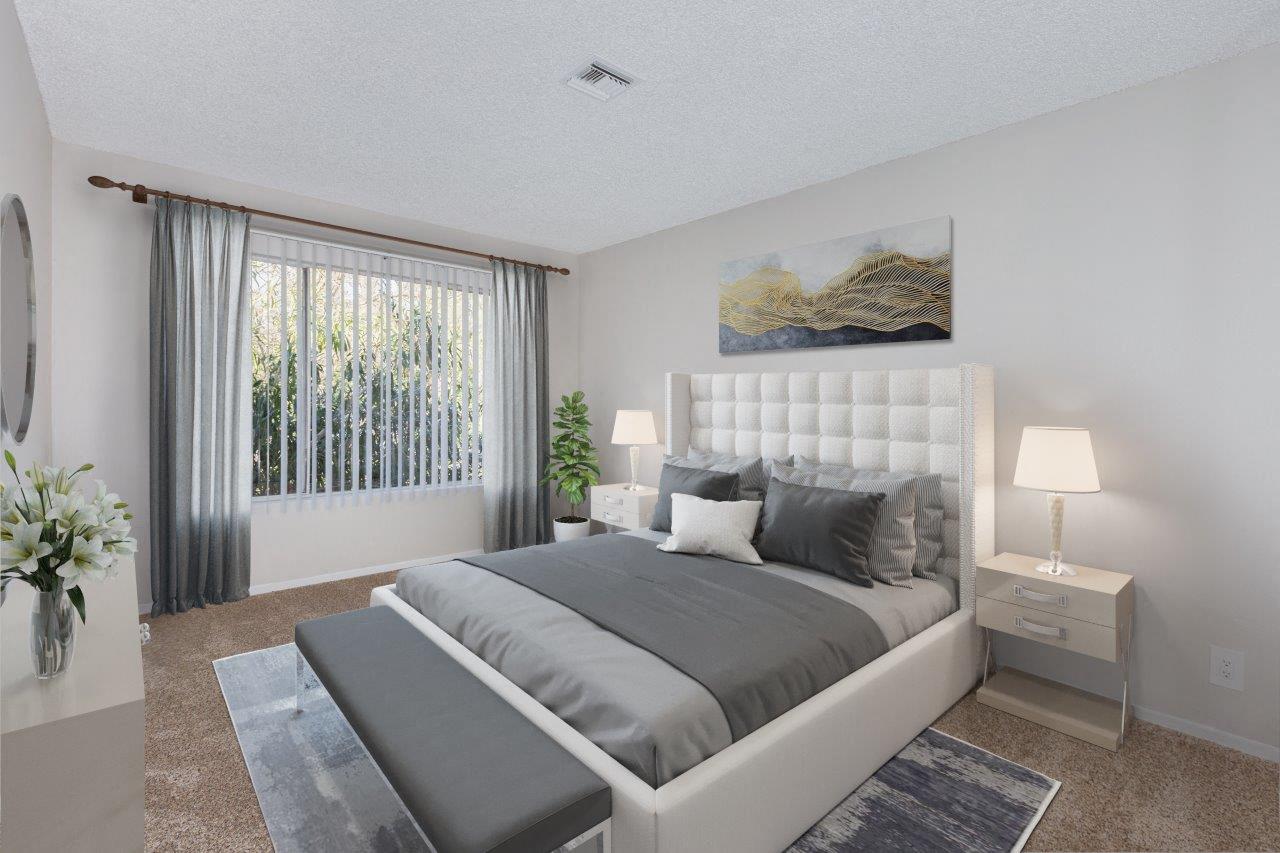 A bedroom with a large bed, a nightstand with a lamp, and a painting on the wall.