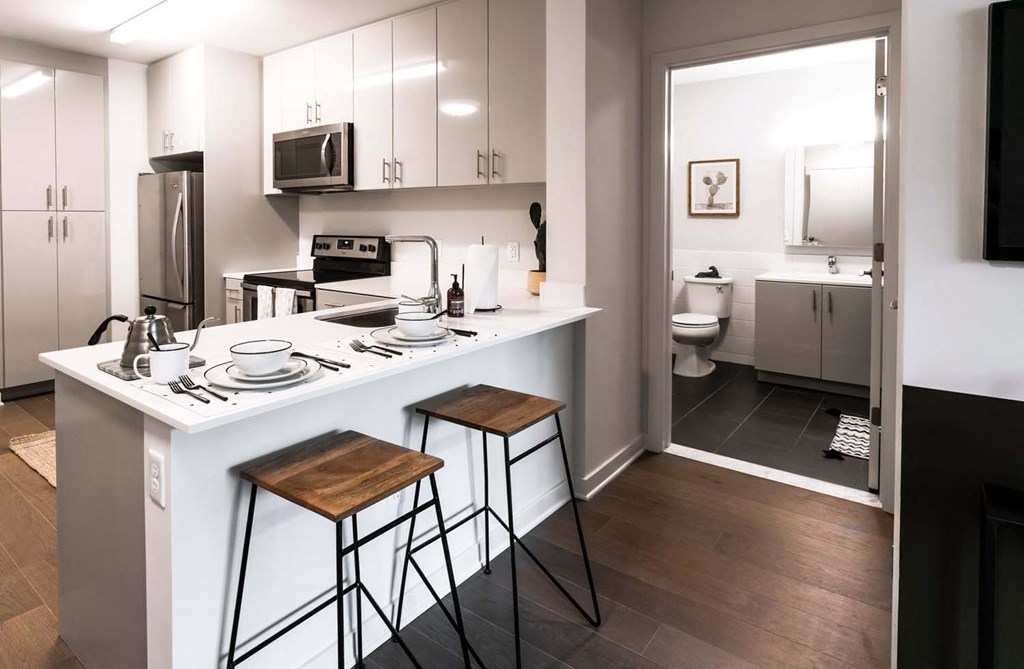 a kitchen with a sink and a counter with stools