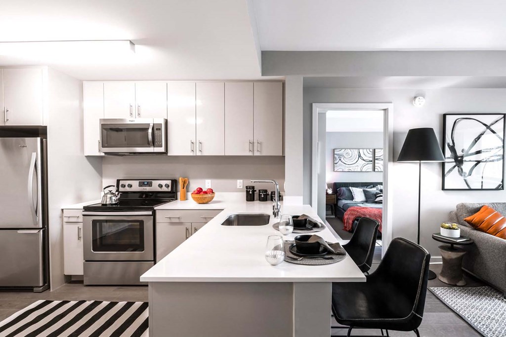 a kitchen and living room with a white counter top