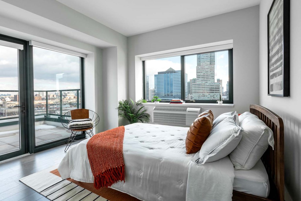 a bedroom with a bed and a view of the city