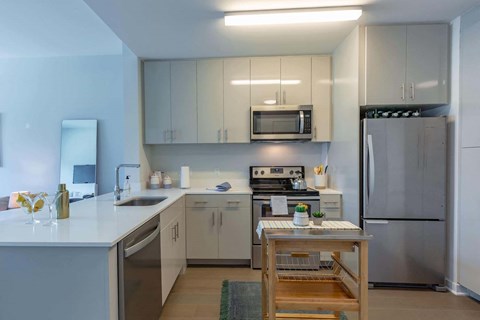 a kitchen with white cabinets and stainless steel appliances