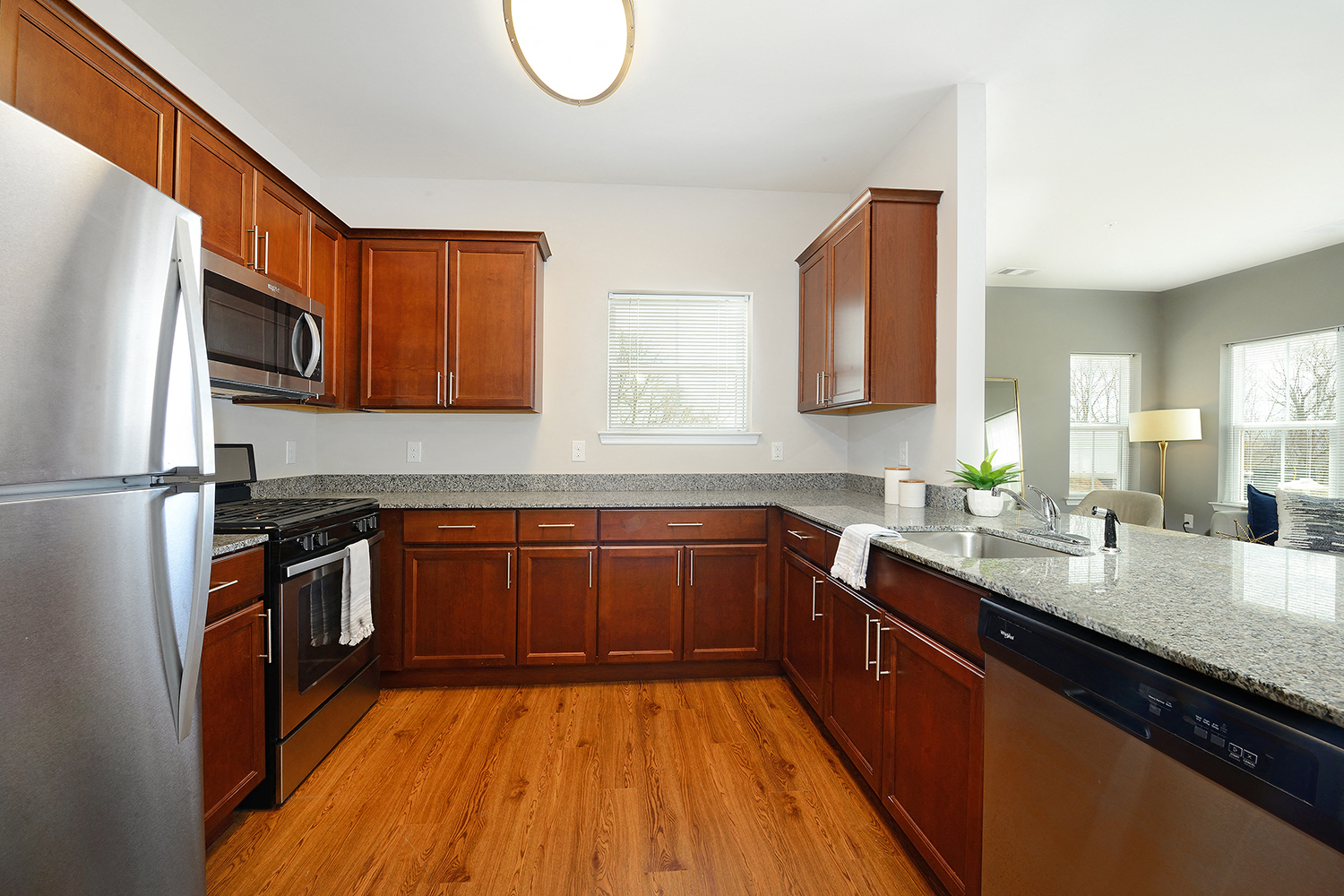 a kitchen with wooden cabinets and granite counter tops and stainless steel appliances