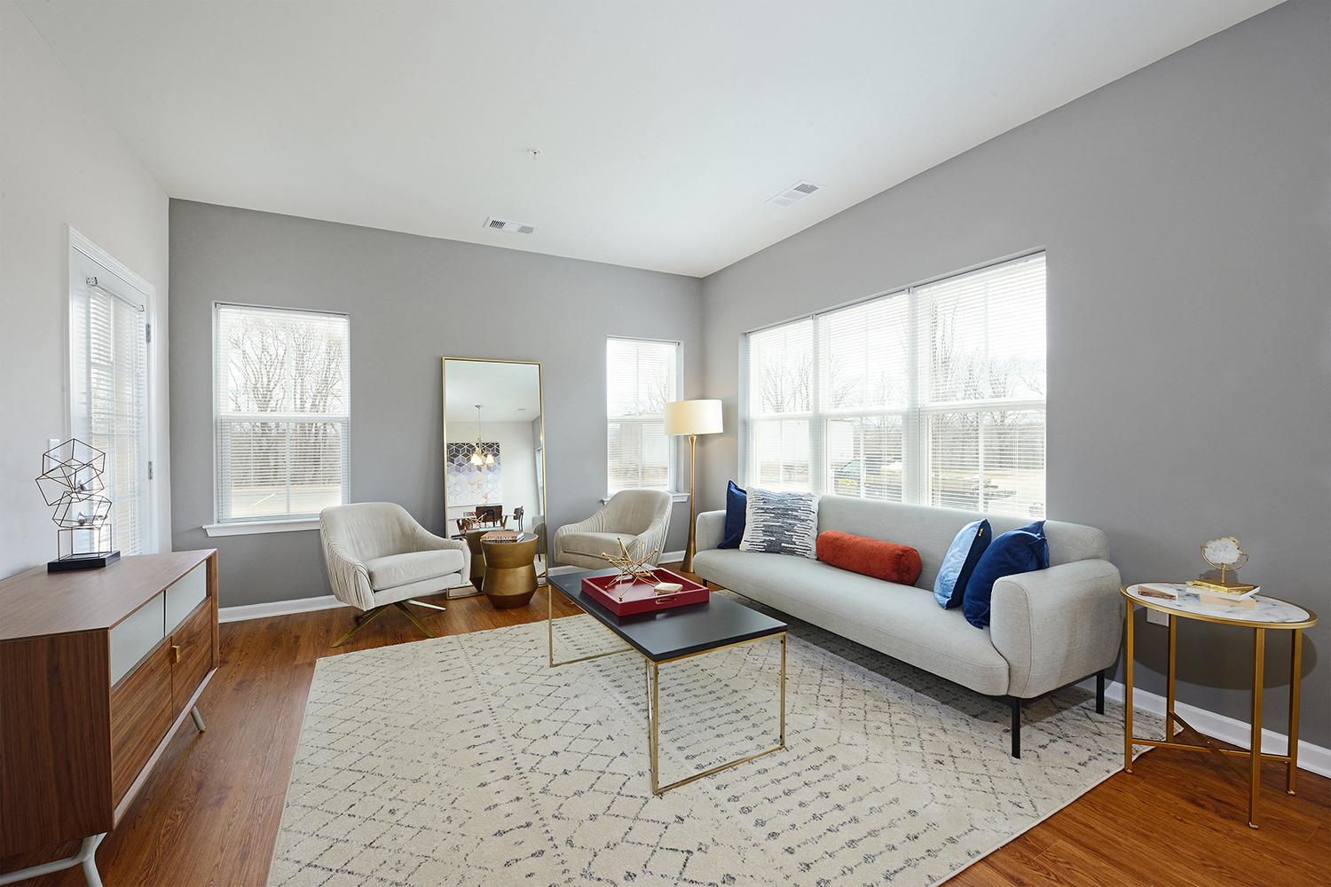 a living room with a couch and two chairs and a rug