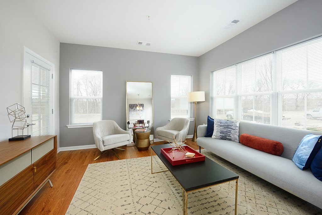 a living room with a couch and two chairs and a coffee table