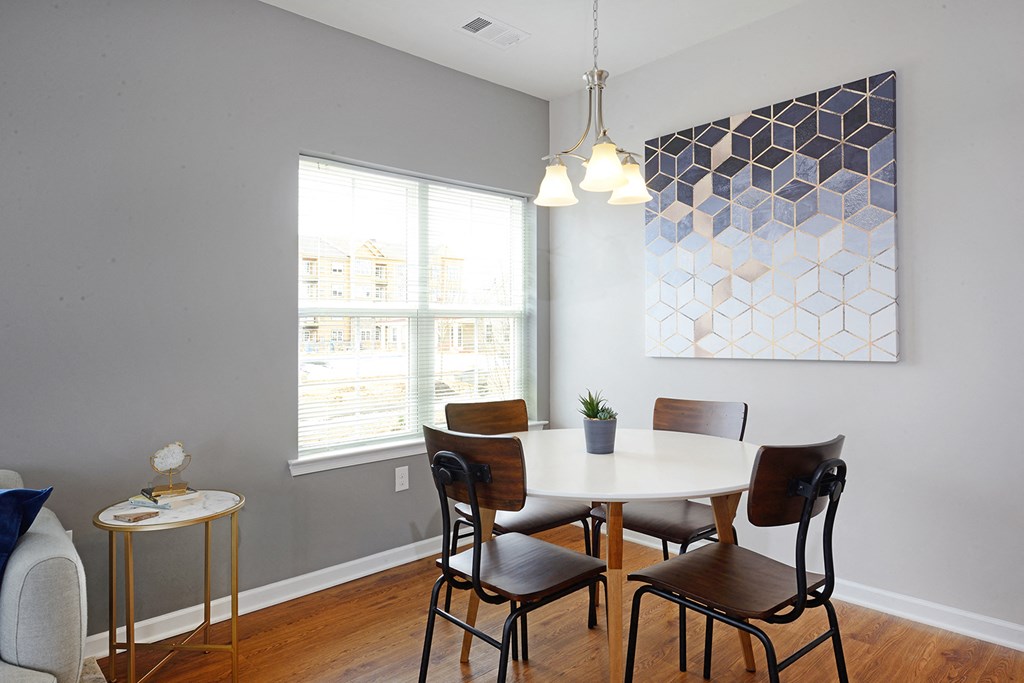 a dining room with a white table and chairs and a window