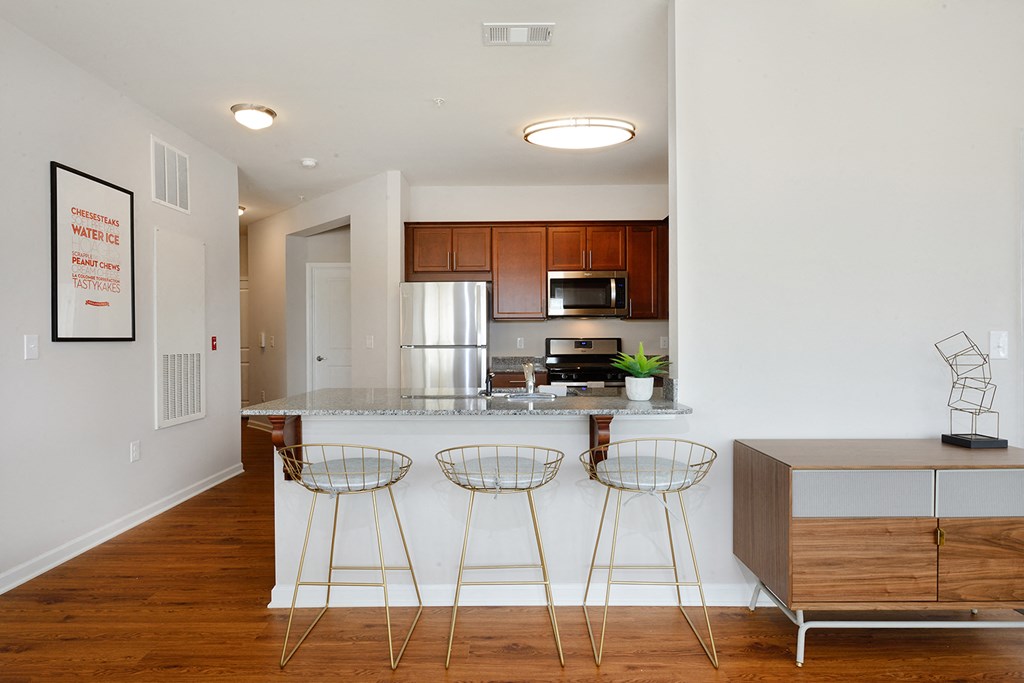 a kitchen with a counter top and three bar stools