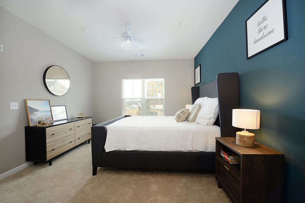 a bedroom with a bed and a dresser and a window