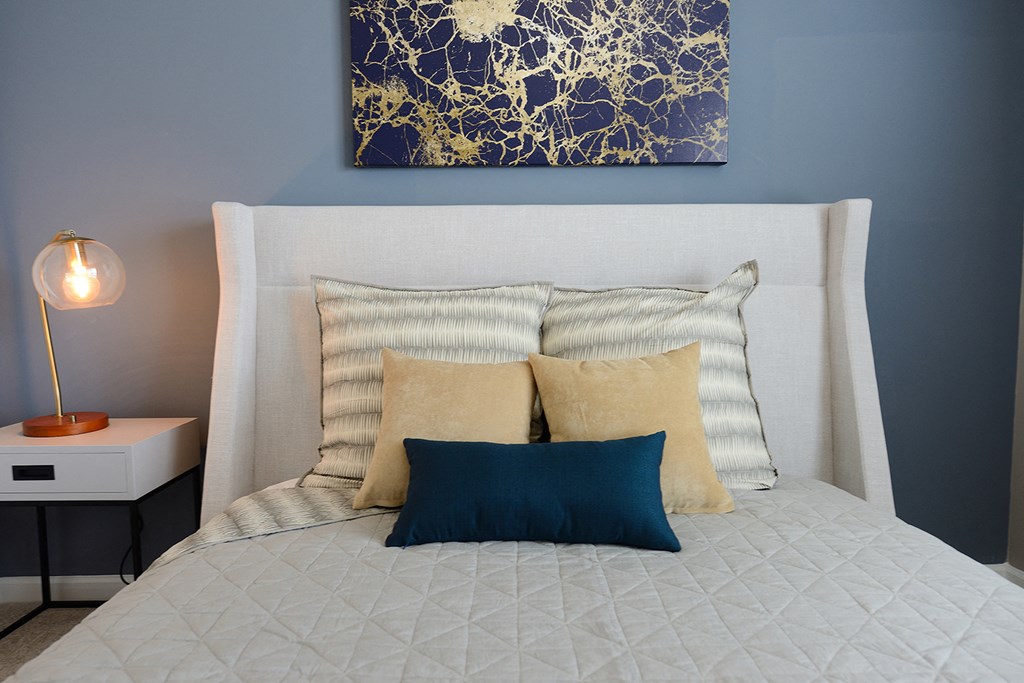 a bedroom with blue walls and a bed with pillows